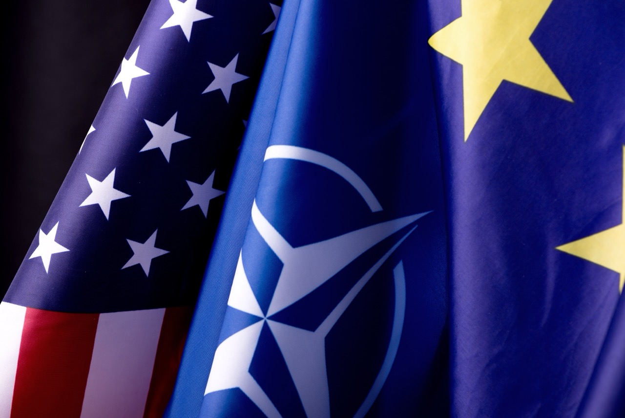Ukraine, Kyiv - 10.04.2023. Official Flags of the US, United Europe and NATO, symbols of Freedom, Patriotism, and Alliance. Two flags against a black background.